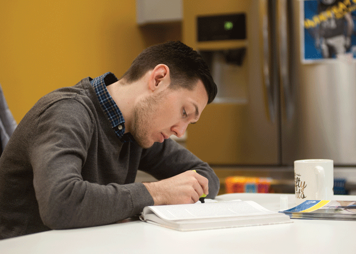 Student studying, reading a textbook.