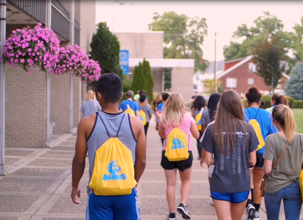 Group of students walking outside of the Moore Center in the Quad.